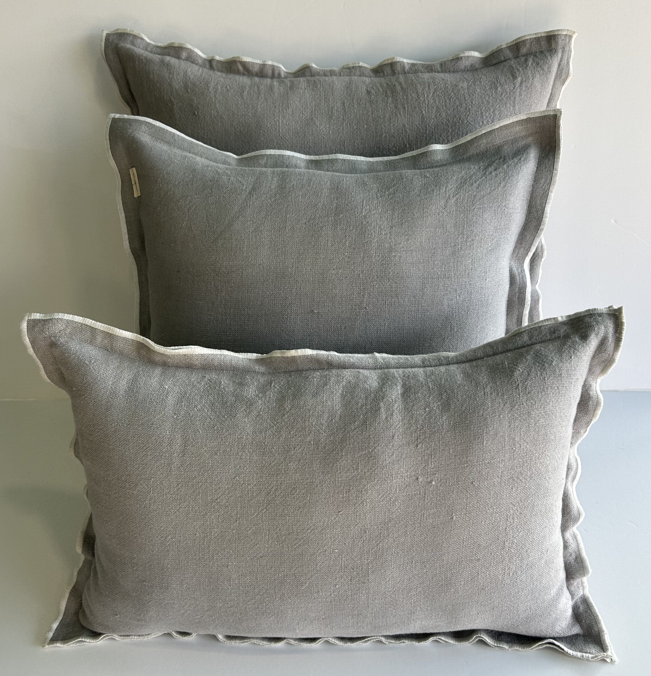 Cojín de Lino Light Grey con pestaña y Overlocado en Blanco.